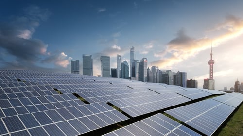 Paisaje urbano moderno con paneles solares y rascacielos bajo un cielo dramático