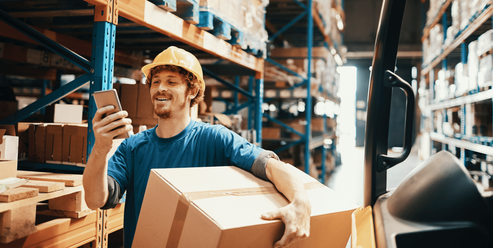 Worker in warehouse using mobile device – physical asset management for logistics and control