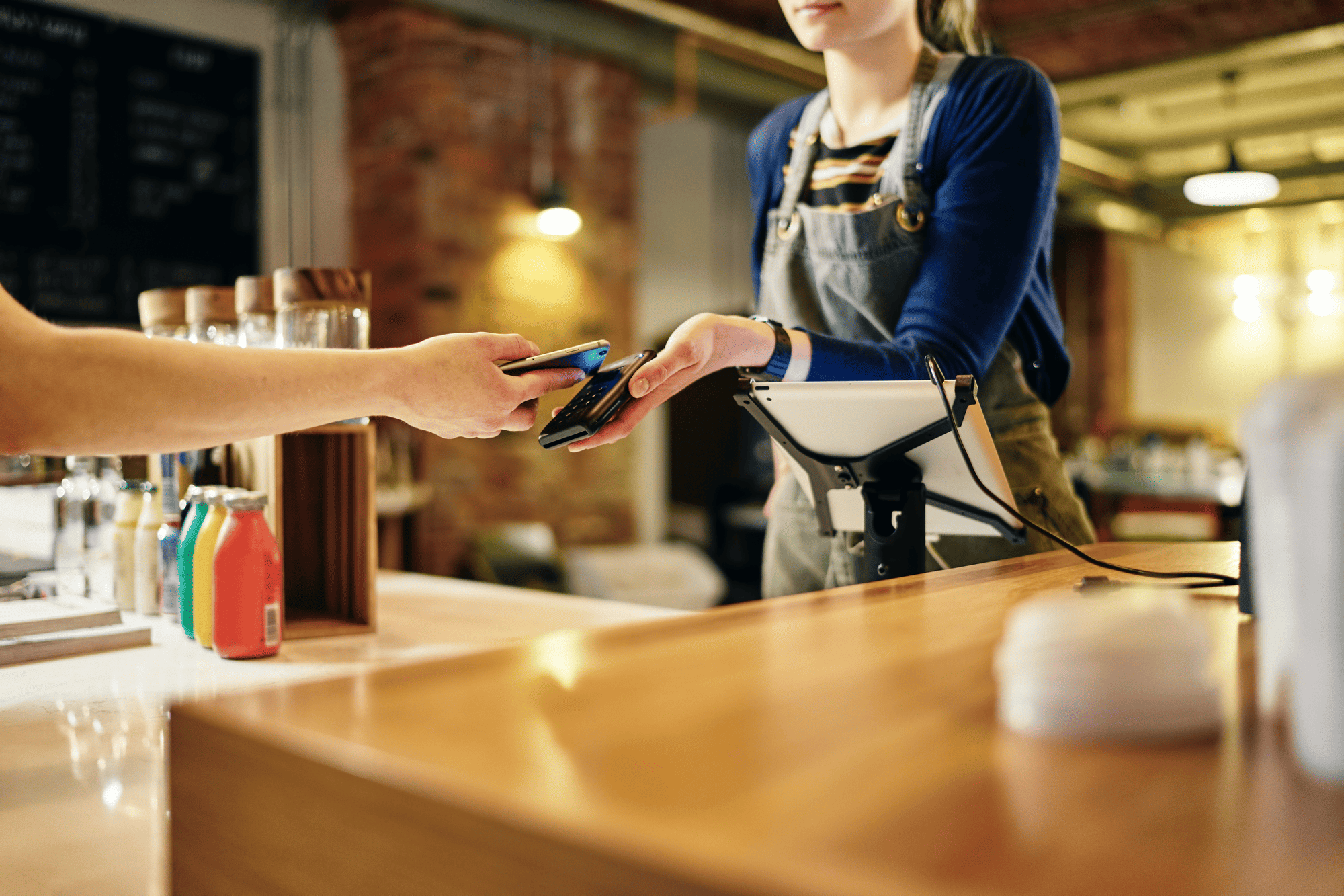 Retail worker processing contactless payment – asset management for specialized retail