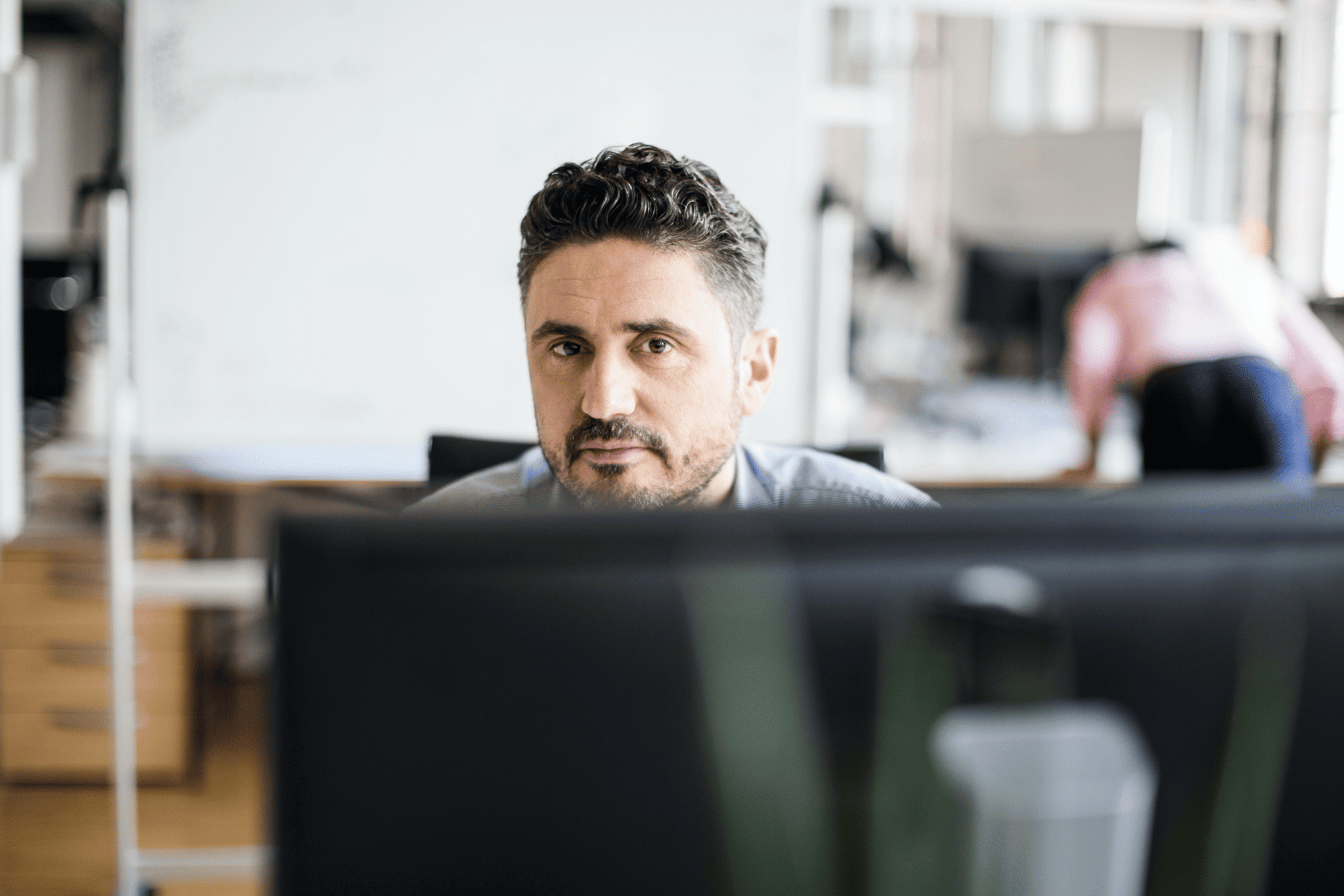 Man at computer in office – manual audit processes prone to error.