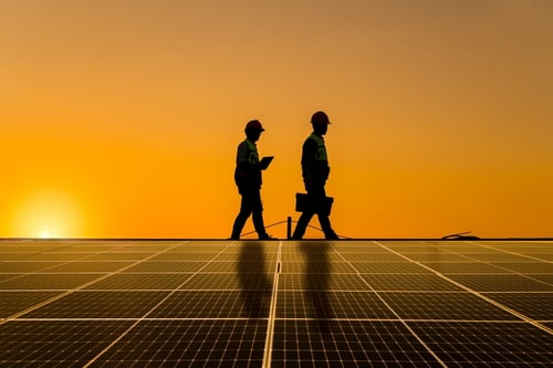 Los ingenieros de Silhouette, mientras caminan por el tejado, inspeccionan y comprueban los paneles solares sujetando la caja de equipos y utilizando la radio; la energía solar forma parte del concepto de una planta de energía alternativa que aprovecha la luz solar, integrada en una red eléctrica inteligente y respetuosa con el medio ambiente.