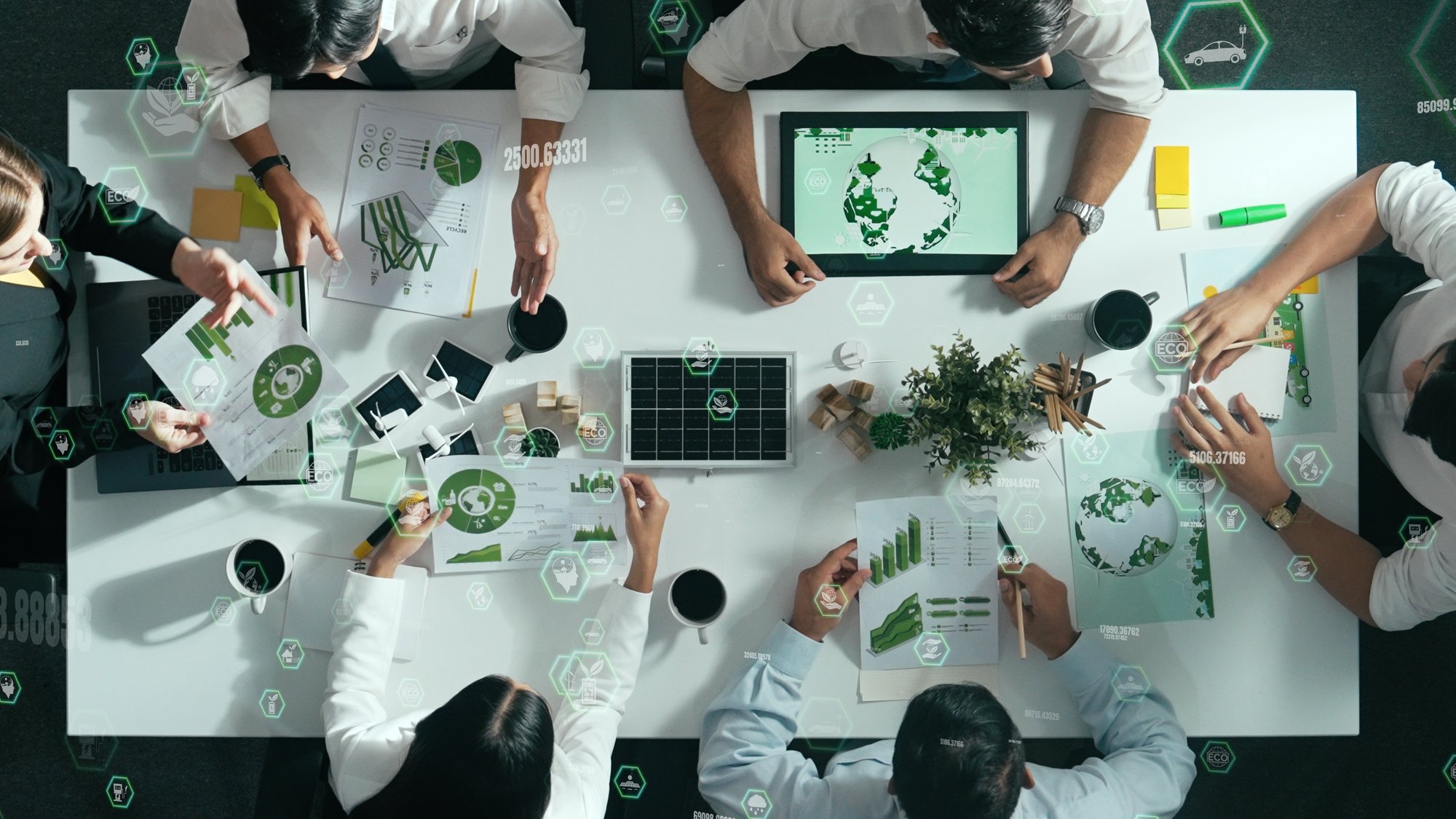 Overhead view of diverse team working with digital sustainability charts – reflecting Nextbitt’s core values